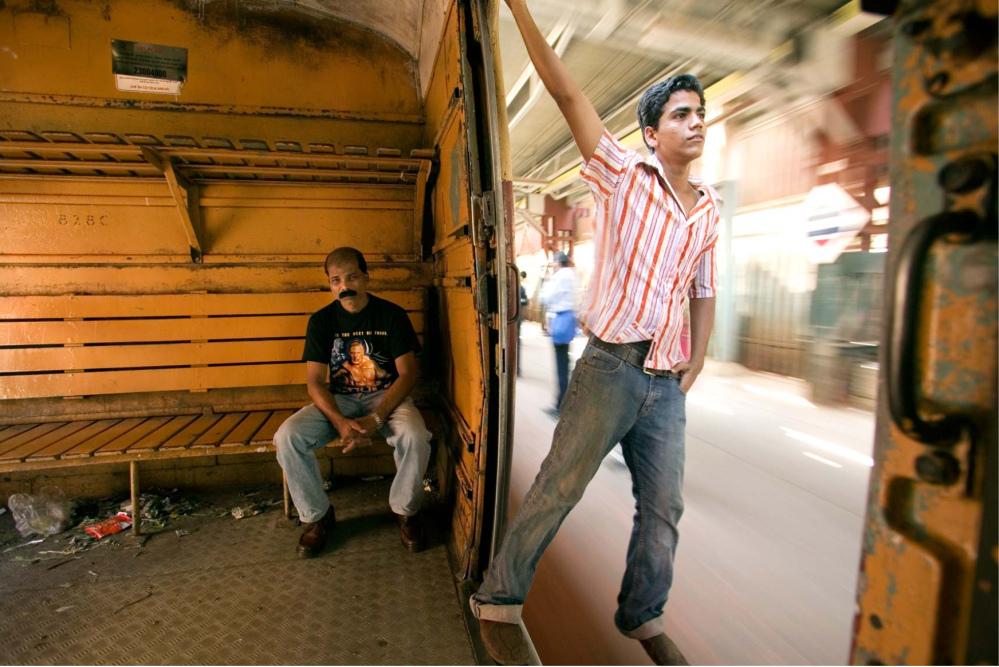 TRAVEL IMAGES ©JASON FLORIO - MAN HANGS OFF A MOVING TRAIN IN INDIA